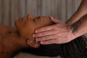 a man getting his head examined by a chiropractor at Pousada Zinga Vila de Caraíva in Caraíva