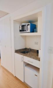 Una cocina con gabinetes blancos y un microondas. en RANCHO TANGUERO EN EL OBELISCO en Corrientes 818, en Buenos Aires