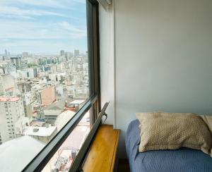 Un dormitorio con vista a una ciudad desde una ventana. en RANCHO TANGUERO EN EL OBELISCO en Corrientes 818, en Buenos Aires 42 fotos más
