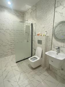 un bagno bianco con un water e un lavandino di غرفة وصالة سوبر فندقية فاخرة a Gedda