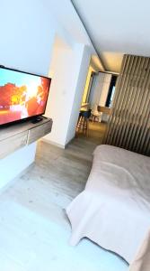 a bedroom with a bed and a flat screen tv at departamento boutique centrico- villa carlos paz in Villa Carlos Paz