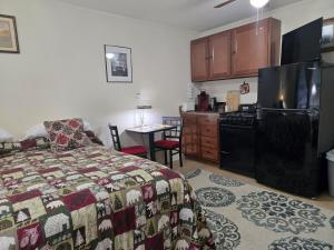 a bedroom with a bed and a kitchen with a table at Saranac Lake Studio Apartment in Saranac Lake