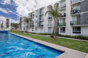 a swimming pool in front of a building at Depa Aria Puebla in Sanctórum