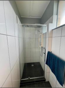 y baño con ducha y toalla azul. en Comfortinn Motel Inglewood, en Inglewood