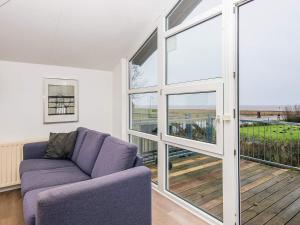 a living room with a purple couch and sliding glass doors at 16 person holiday home in Højer in Højer