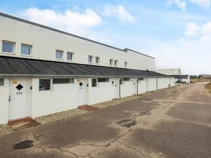 a white building with a row of garage doors at 6 person holiday home in Brovst in Brovst
