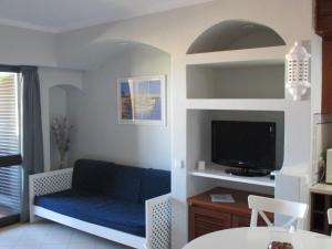 sala de estar con sofá azul y TV en Bellavista Mar, en Albufeira