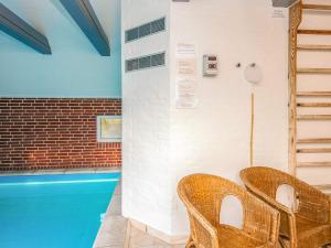zwei Korbstühle neben einem Pool in der Unterkunft 4 star holiday home in Blåvand in Blåvand