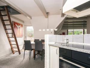 eine Küche mit Tisch und Stühlen und einer Leiter in der Unterkunft 4 star holiday home in Blåvand in Blåvand