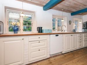 a kitchen with white cabinets and windows at 4 star holiday home in Højer in Højer