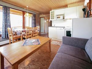 a kitchen and living room with a table and a couch at 4 person holiday home in Risør in Risør
