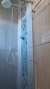 une douche avec une porte vitrée dans une salle de bain dans l'établissement Casa simples, à Tremembé