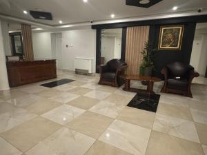 een lobby met 2 stoelen, een bureau en een tafel bij Hotel Cataleya in Šabac +74 foto's