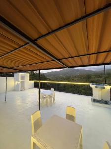 a patio with a table and chairs under a roof at Sierra Serena Habitaciones in Santa Marta