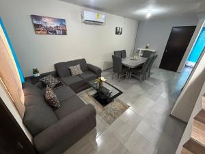 ein Wohnzimmer mit Sofa und Tisch in der Unterkunft Casa Punta del Este Paraiso Tabasco in Paraíso