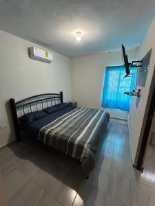 ein Schlafzimmer mit einem Bett und einem blauen Fenster in der Unterkunft Casa Punta del Este Paraiso Tabasco in Paraíso