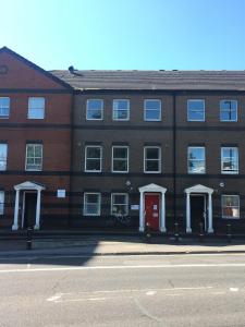 a brick building with a red door on a street at Southampton Haven in Southampton +38 photos