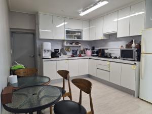 a kitchen with white cabinets and a table and chairs at Gotaya Guesthouse in Andong +48 photos