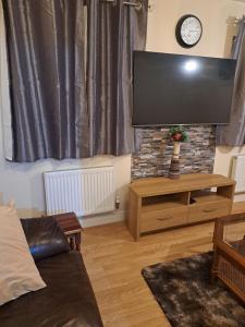 a living room with a large flat screen tv at Mekees Luxury Apartment in Tipton