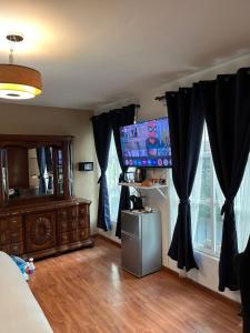 a bedroom with black curtains and a tv on the wall at SúperAnfitrión Coyoacán King 1 in Mexico City +28 photos