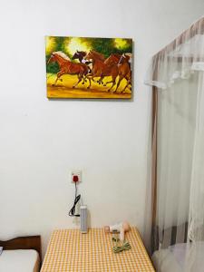 a painting of horses running on a table in a room at Khongaha Villa Holiday Home #AC in Mirissa