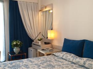 
a bedroom with a bed and a dresser at The Park Hotel Piraeus in Piraeus

