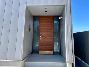 高松市にあるGARDENIA Sunsetの廊下に木製の扉がある建物