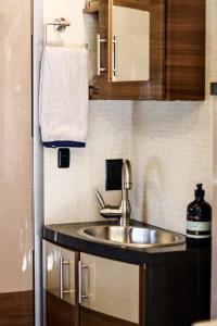 a bathroom with a sink and a towel at Navi- HUGE yard- MEGA playset- CUTE RV in Willmar +34 photos