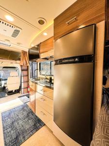 a kitchen with a stainless steel refrigerator in an rv at Navi- HUGE yard- MEGA playset- CUTE RV in Willmar