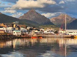 a harbor with a town and a mountain in the background at Casa linda in Ushuaia
