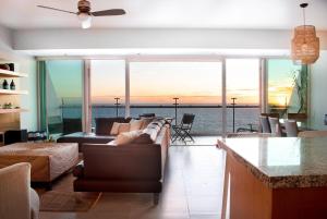 a living room with a couch and a view of the ocean at Condo de lujo en Mazatlan Peninsula in Mazatlán