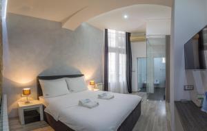 a bedroom with a large white bed and a bathroom at Central Park Residence in Belgrade