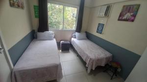 ein Zimmer mit zwei Betten und einem Fenster in der Unterkunft Apartamento Porto Real in Mangaratiba + 37 Fotos