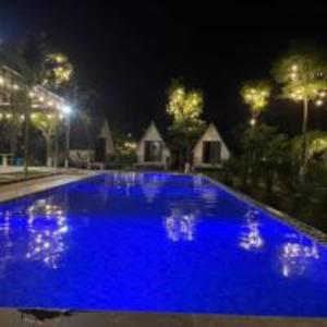 バヴィにあるHương Cỏ Villa Venuestayの夜間の青い大型スイミングプール(照明付) +13枚の写真