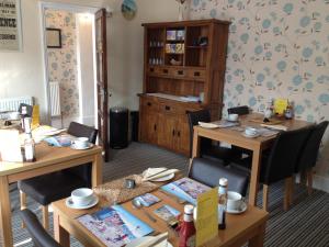 un comedor con 2 mesas y sillas y un armario en Sandcastles Guest House, en Great Yarmouth