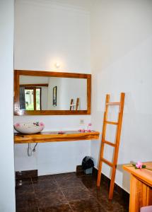 une salle de bain avec un lavabo et un miroir au mur dans l'établissement Alwi Villa Gili Trawangan, à Gili Trawangan