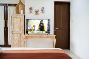 a bedroom with a television on a wooden stand at Massive 3 bedroom villa in heart of Seminyak in Seminyak