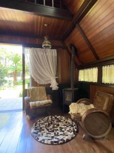 a living room with a stove and a chair at Chalé Nardi in Canela +9 photos
