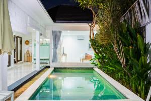 a swimming pool in a villa with a house at Massive 3 bedroom villa in heart of Seminyak in Seminyak