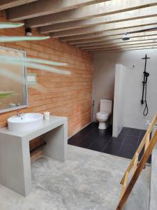 een badkamer met een wastafel en een toilet bij Eco Bricks in Ahangama +12 foto's