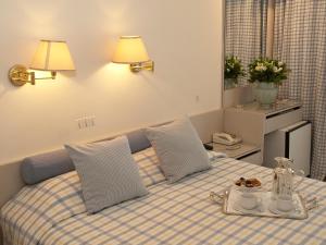 
a bed with two pillows and a blanket on top of it at The Park Hotel Piraeus in Piraeus
