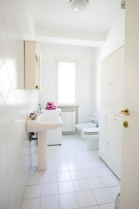 biała łazienka z umywalką i toaletą w obiekcie Orchidea Pineto Vacanza w mieście Pineto