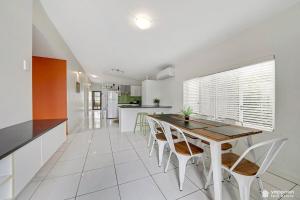 een keuken en eetkamer met een tafel en stoelen bij Air-conditioned Cooee Bay Beach House with Wi-Fi in Yeppoon +15 foto's