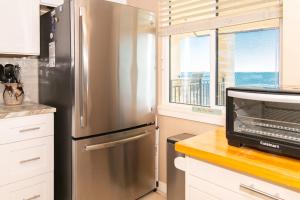 un frigorifero in acciaio inossidabile in una cucina con finestra di Rare View Premium Oceanfront 4 BR a Myrtle Beach