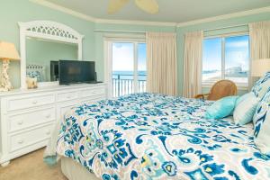 una camera con un letto blu e bianco e una TV di Rare View Premium Oceanfront 4 BR a Myrtle Beach Altre 43 foto