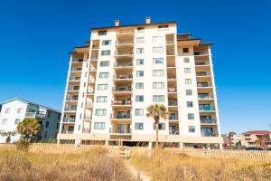 un alto edificio bianco con palme di fronte di Rare View Premium Oceanfront 4 BR a Myrtle Beach