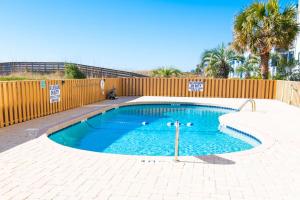 una piccola piscina con recinzione e palme di Rare View Premium Oceanfront 4 BR a Myrtle Beach