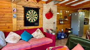 a living room with a couch with a dartboard on the wall at Cabaña en Pichidangui un Oasis de naturaleza y relajación in Pichidangui