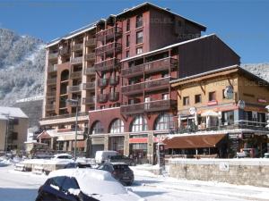 a large building with cars parked in the snow at Appartement familial, 2 chambres, balcon S-E, à 30m pistes et Balnéo, Les Angles - FR-1-295-135 in Les Angles