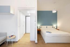 une chambre avec un lit blanc et un canapé blanc dans l'établissement Lomellina 13, à Milan